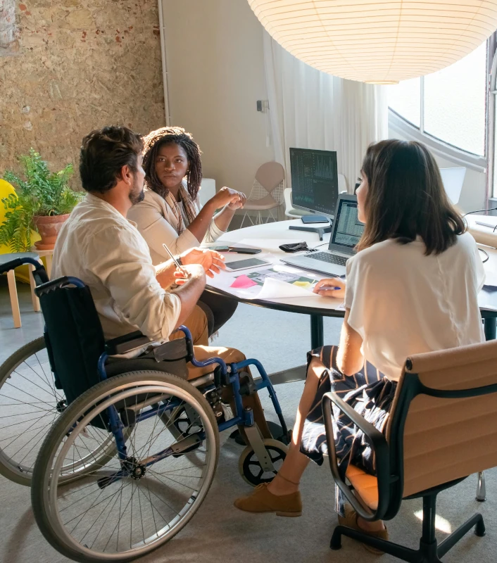 3 personnes autour d'une table travaillent ensemble sur un projet d'accessibilité numérique